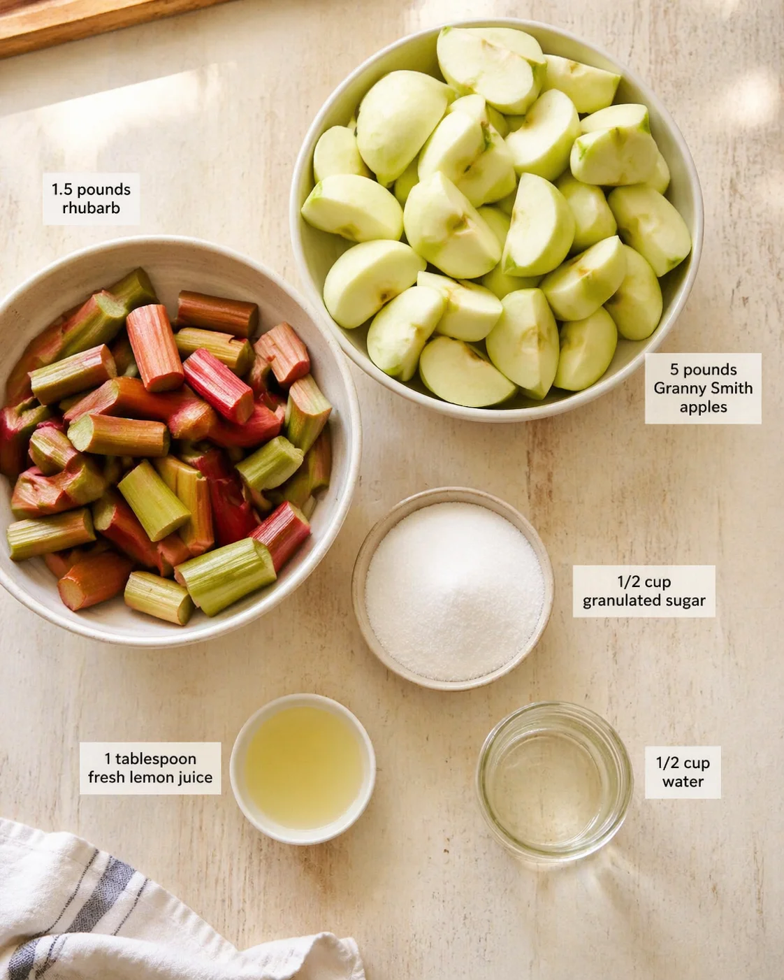 Measured ingredients arranged for Quick Rhubarb Applesauce: fresh lemon juice (about 1 tablespoon for a bright kick), 1.5 pounds rhubarb (trimmed and cut into 2-inch pieces), 5 pounds Granny Smith apples (peeled, cored, 