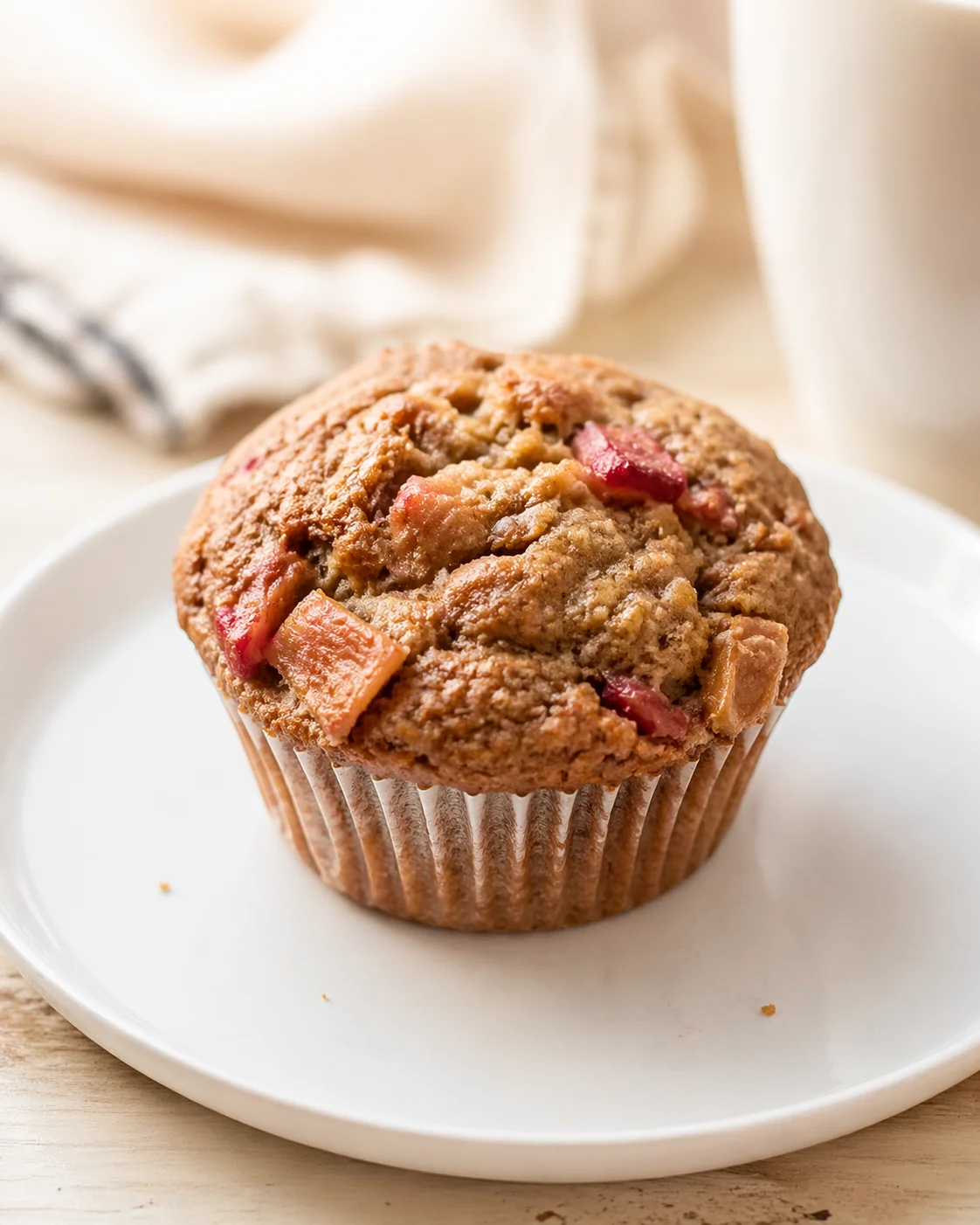 Single plated variation of Whole Wheat Rhubarb Applesauce Muffins shown in a natural kitchen scene