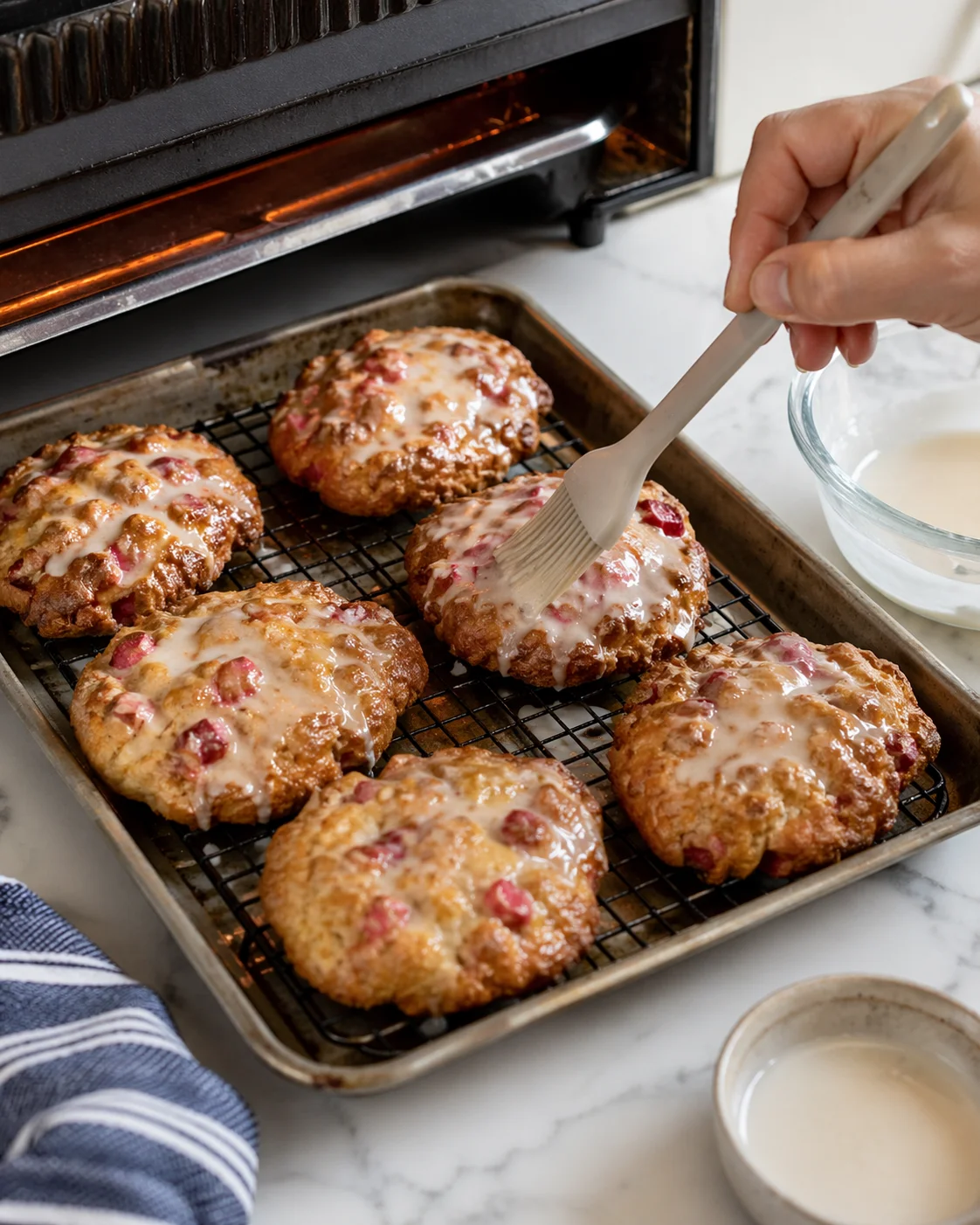 Broiled fritter tops showing caramelized, crackled sugar while second thin glaze is brushed