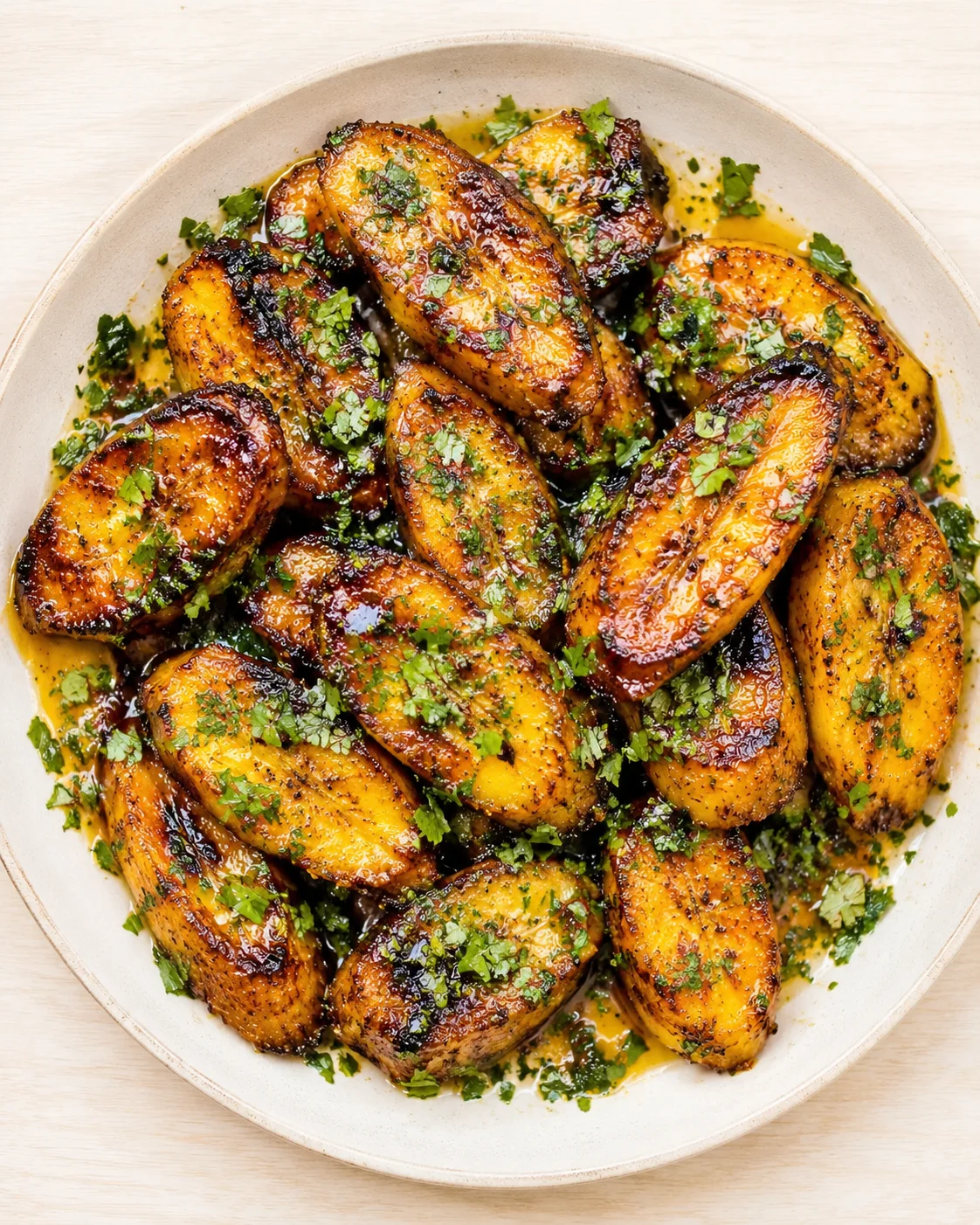 bowl of crispy, caramelized roasted potato wedges garnished with chopped parsley