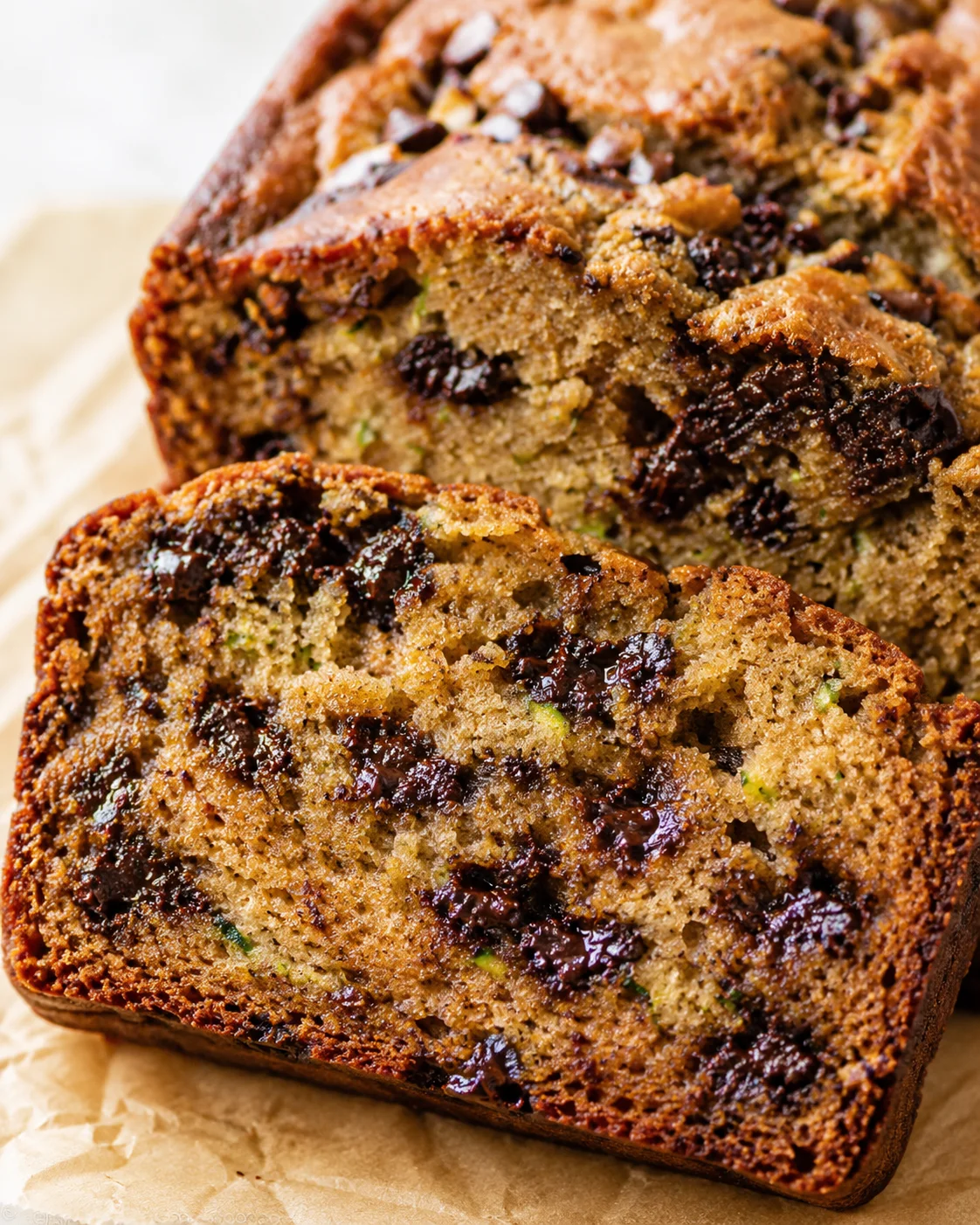 sliced banana-zucchini bread with dark chocolate chips on parchment paper