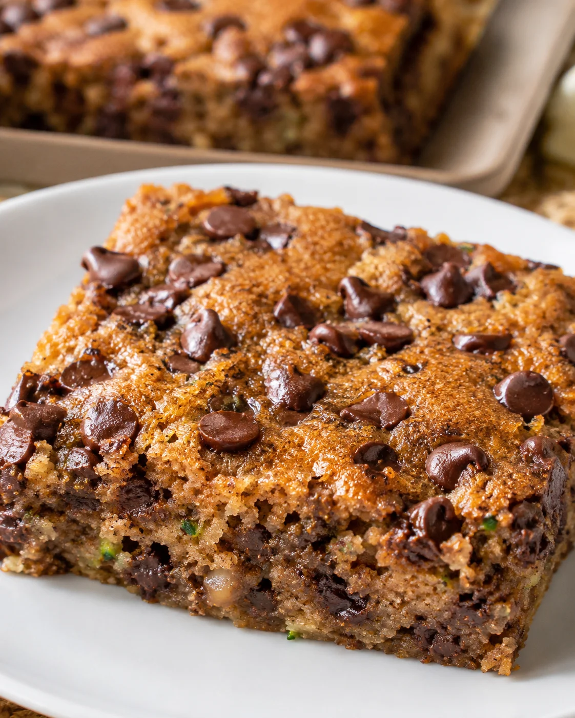 Delicious, chewy chocolate zucchini bars with hidden veggies on a white plate.
