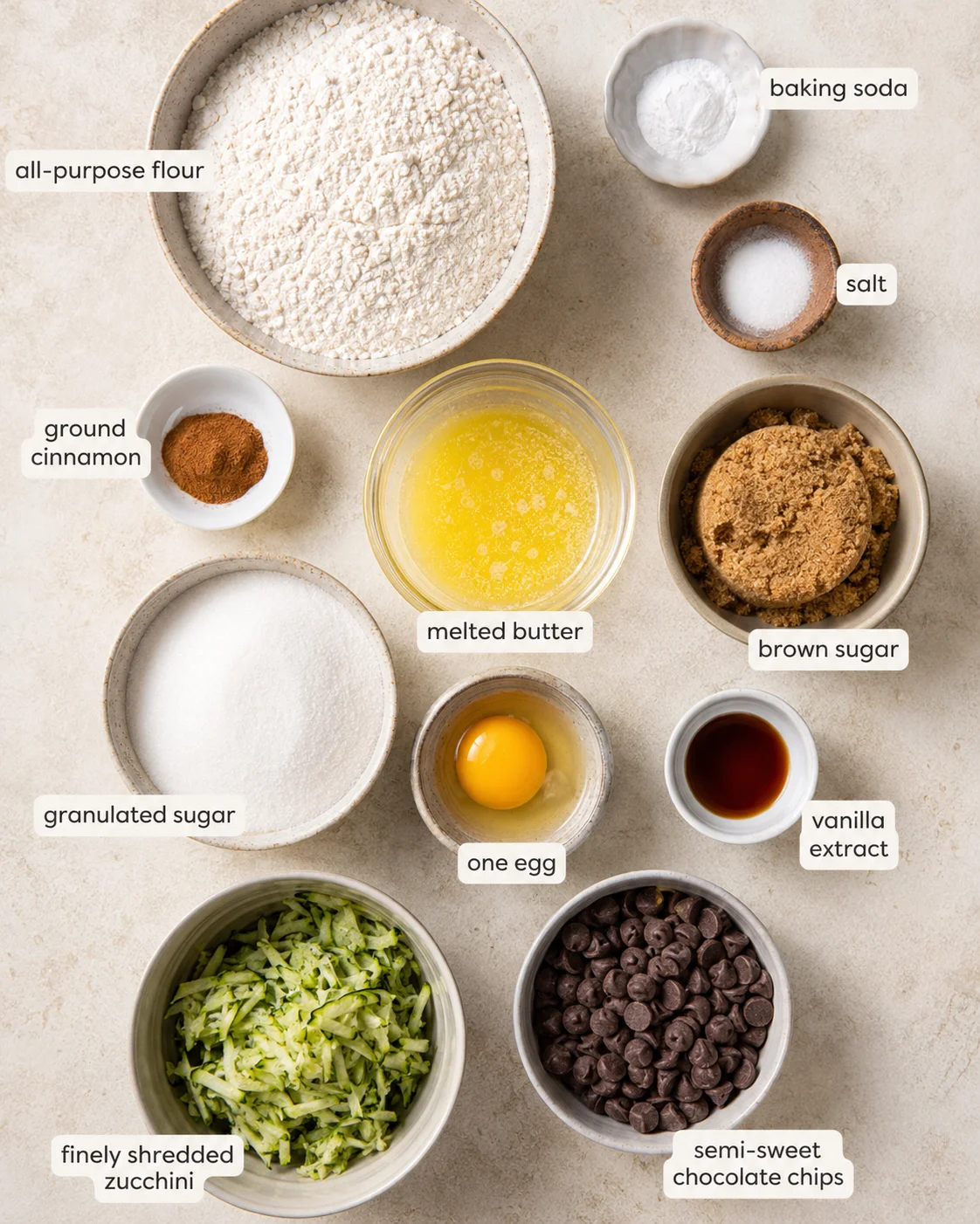 Ingredients laid out for making moist, chocolate chip zucchini bars in a baking dish.