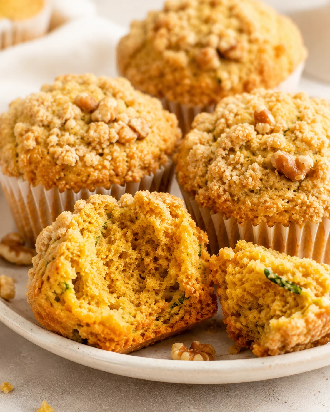 Freshly baked pumpkin zucchini muffins topped with walnuts and crumb topping