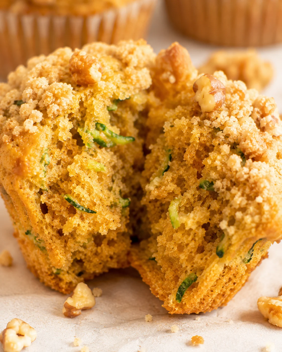 Golden, crumbly muffins filled with pumpkin, zucchini, and topped with walnuts