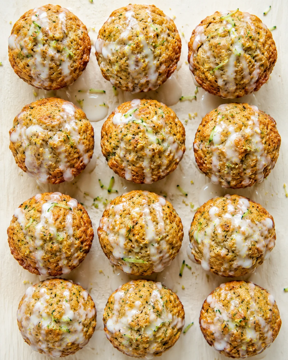 dozen herb-crusted meatballs with white glaze arranged on a light wooden surface