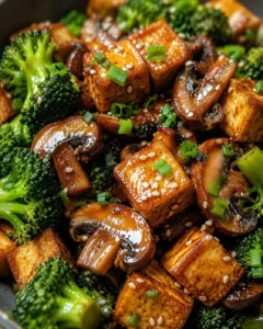 Colorful mushroom and tofu stir-fry with broccoli and sesame seeds.