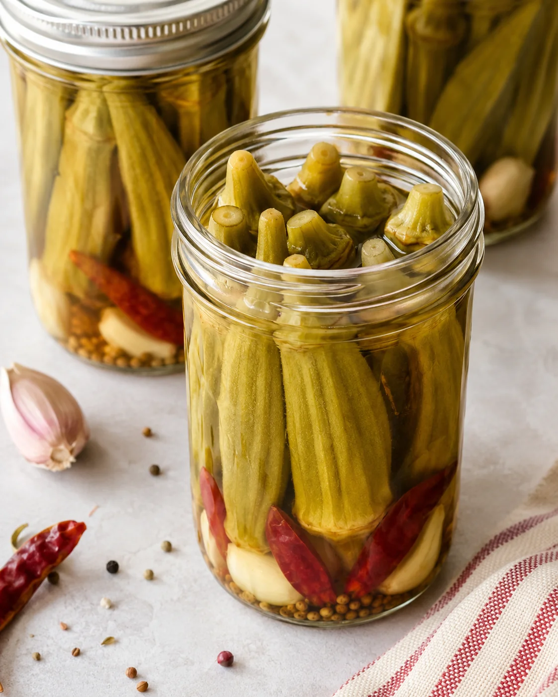 Jars of crisp, homemade pickled okra with flavorful spices and secret ingredient.