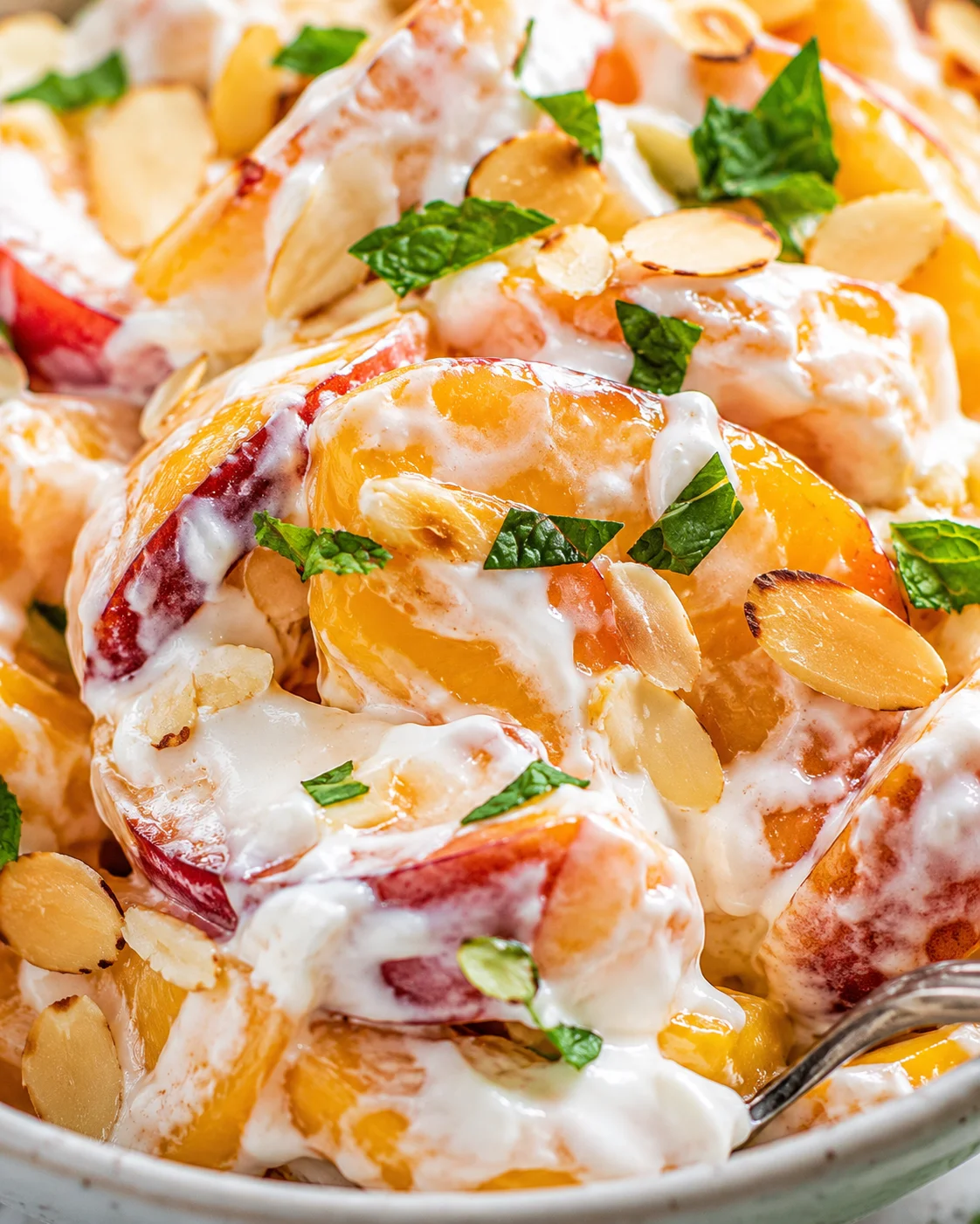 Peaches and Cream Salad: Summer Brightness Close-up of a vibrant peaches and cream salad with almonds and mint leaves