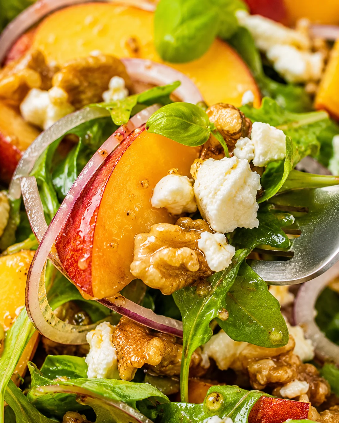 Mediterranean Peach Salad Close-up of fresh peach salad with cheese, basil, and walnuts.