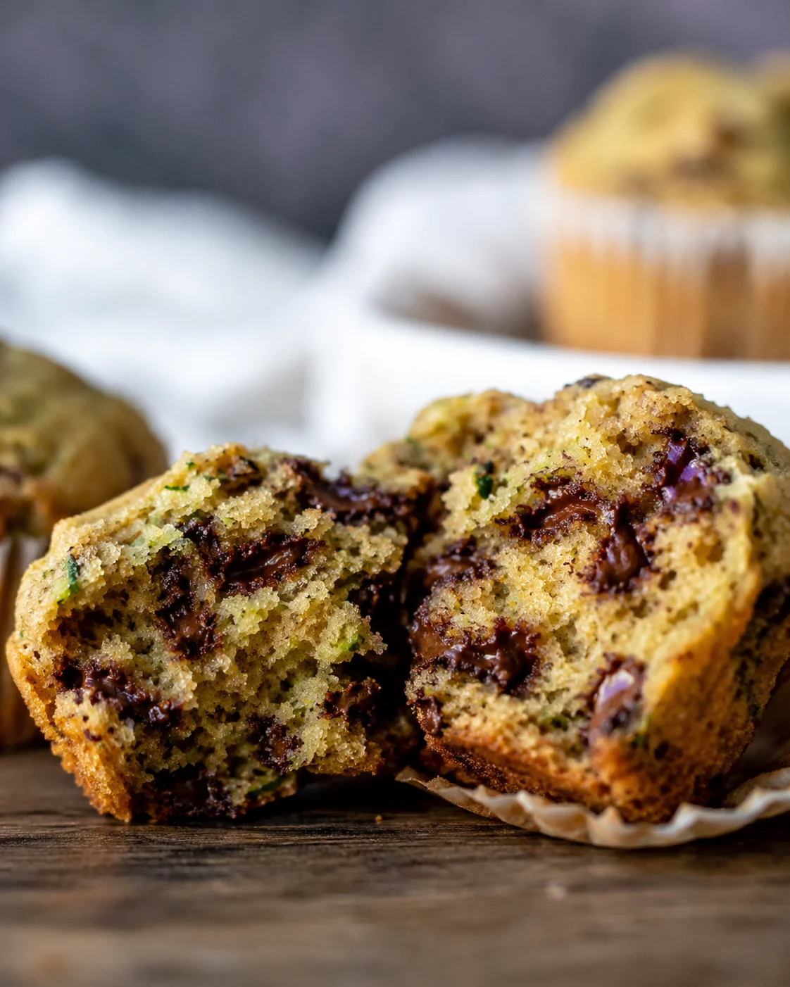 Zucchini Chocolate Chip Muffins Close-up of moist zucchini chocolate chip muffin broken in half showing chocolate filling