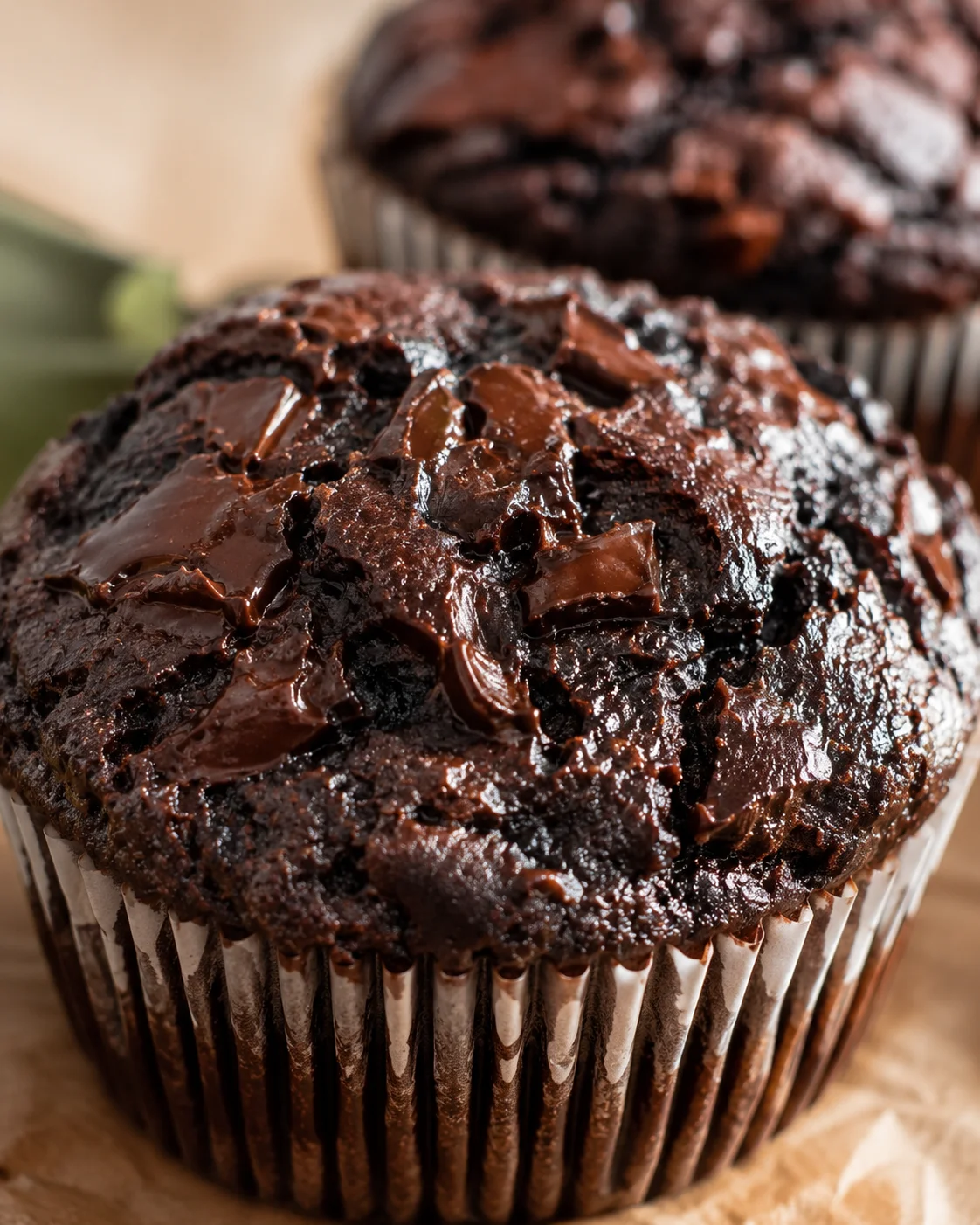 Close-up of delicious, fudgy chocolate zucchini muffins with melted chocolate on top.