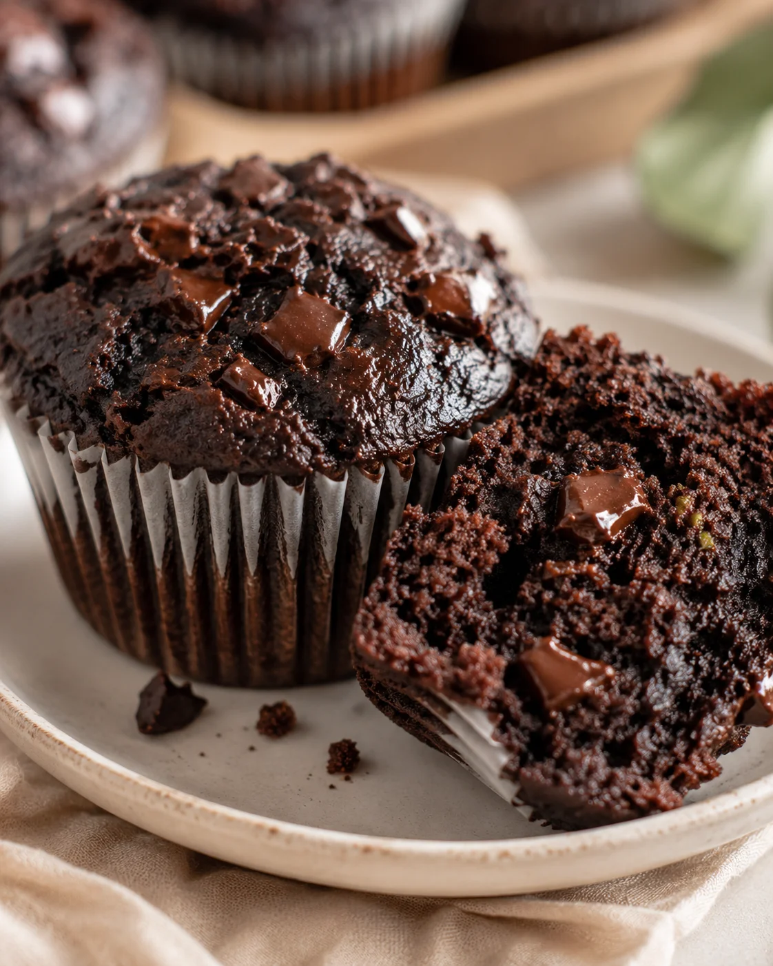 Delicious, moist chocolate zucchini muffins with chunks of chocolate on top.