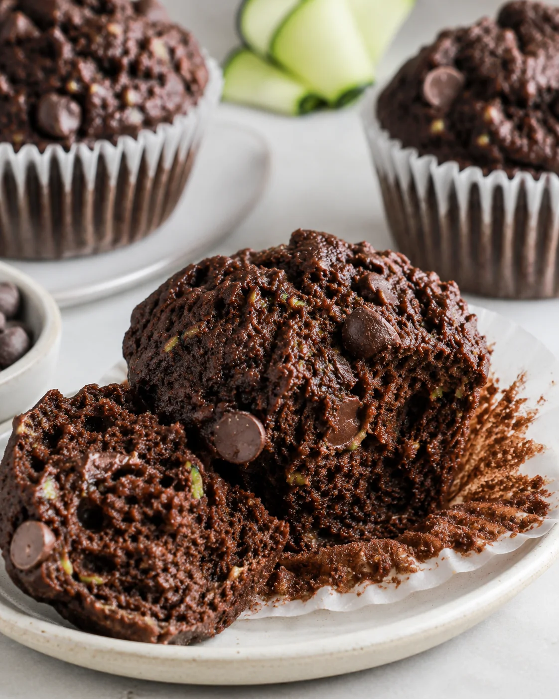 Chocolate Zucchini Muffins Freshly baked moist chocolate zucchini muffins with chocolate chips on a plate.