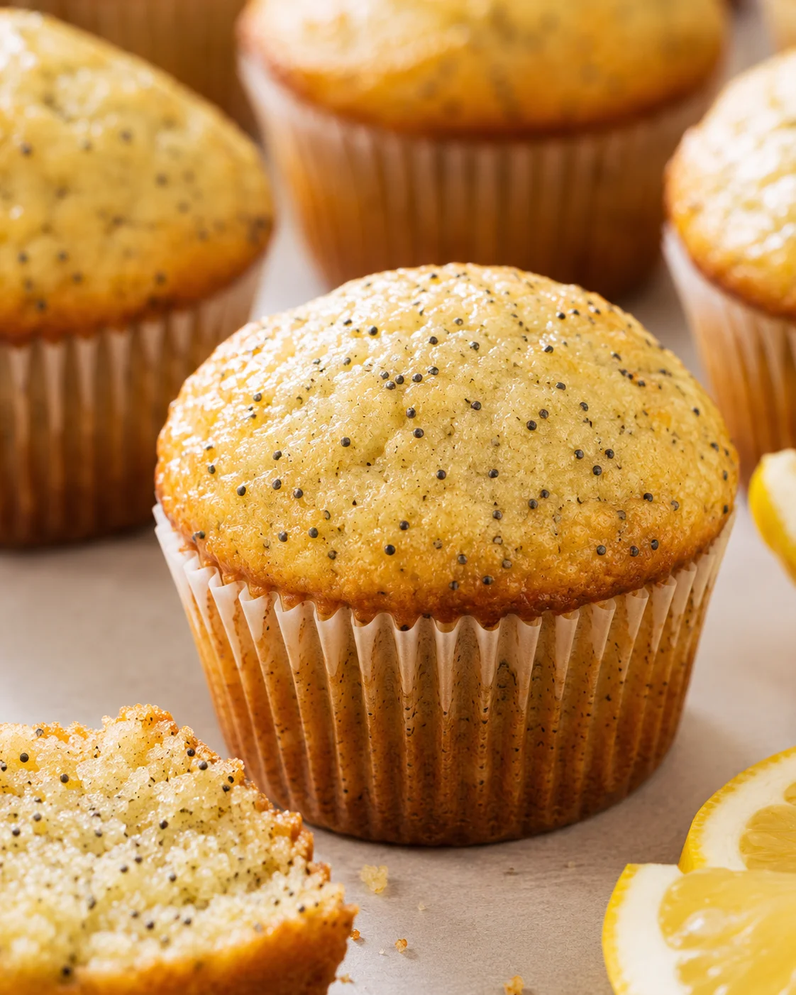 Freshly baked lemon poppy seed muffins with a bright glaze and tall domed tops
