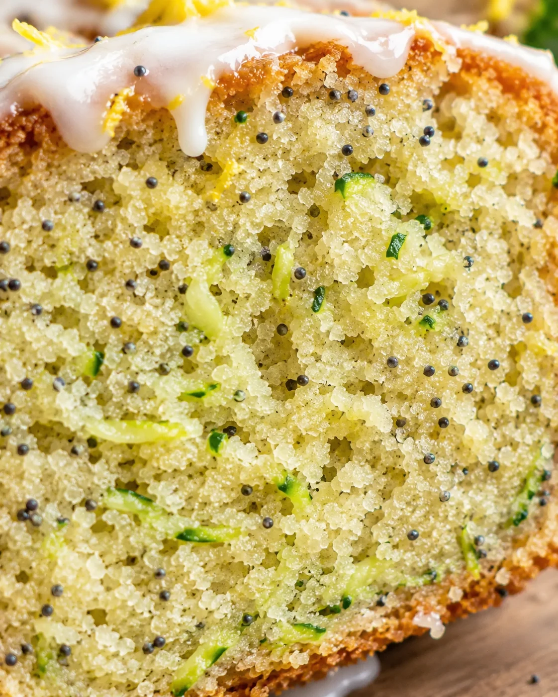 Lemon Poppy Seed Zucchini Bread Close-up of sliced lemon zucchini bread with poppy seeds and glaze.
