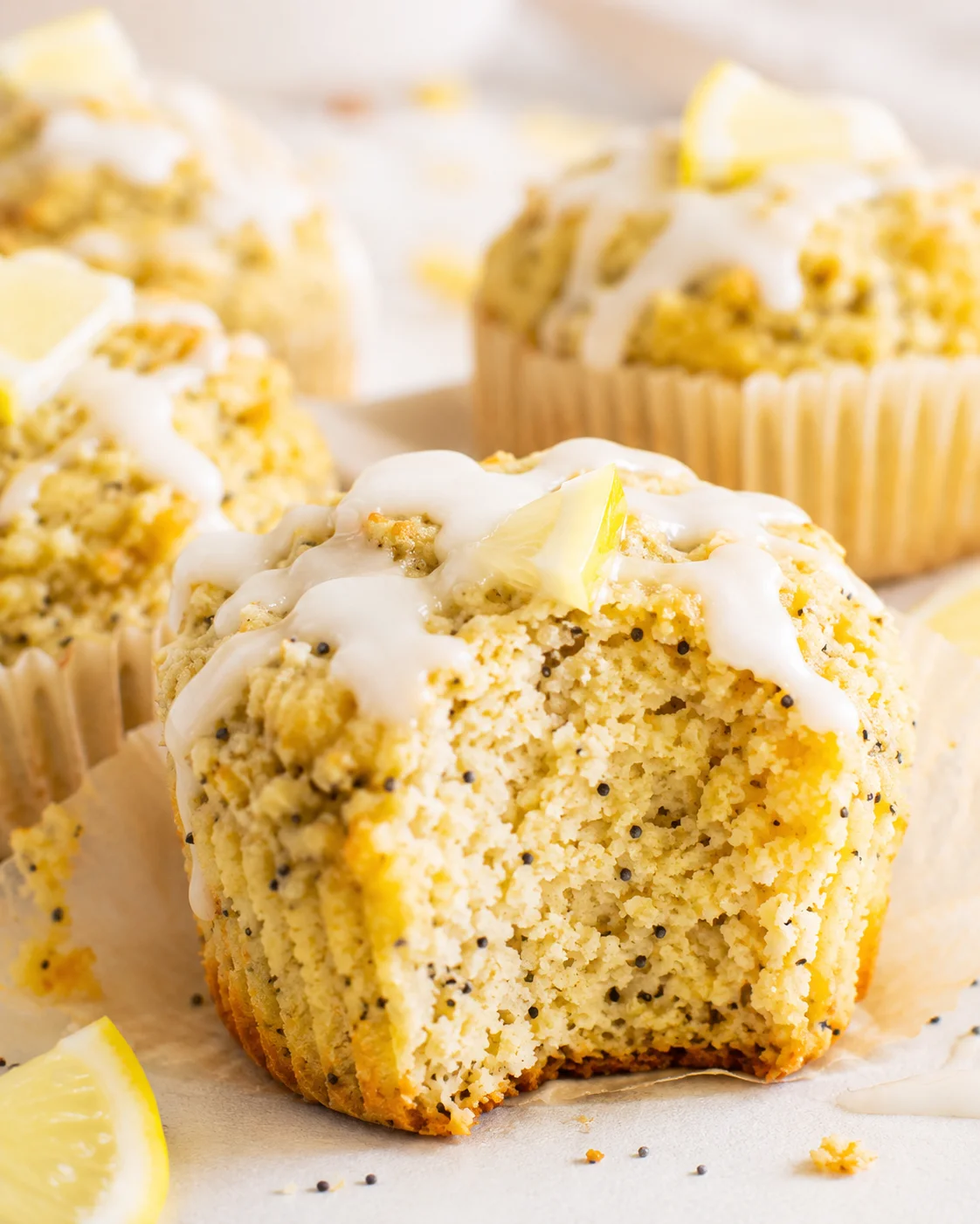 Close-up of fresh lemon poppy seed muffins topped with lemon glaze and slices