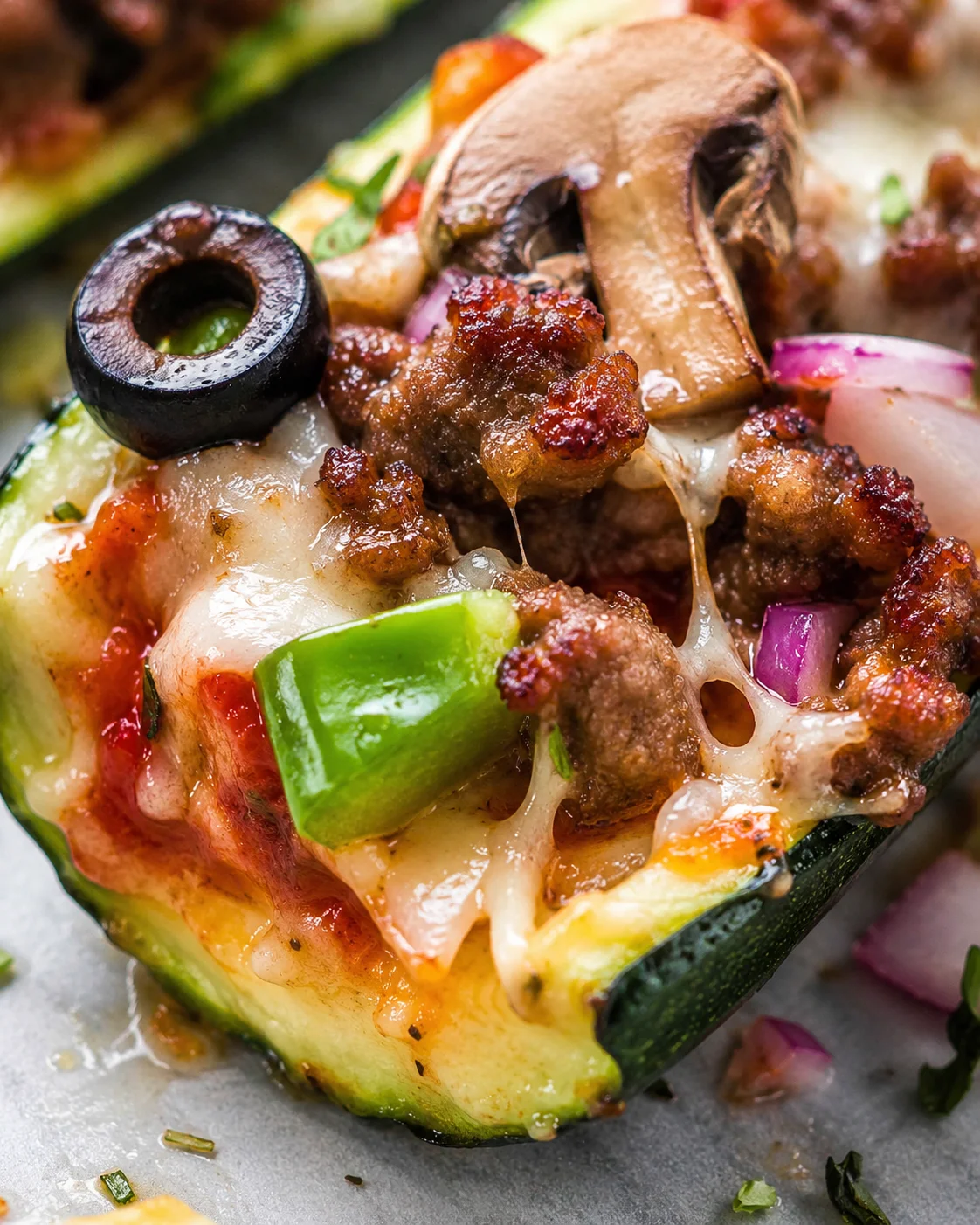 Zucchini Pizza Boats Delicious Recipe Close-up of zucchini pizza boats topped with cheese, sausage, and vegetables