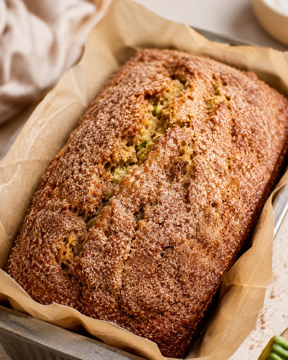 Freshly baked snickerdoodle zucchini bread with cinnamon sugar crust in a baking pan