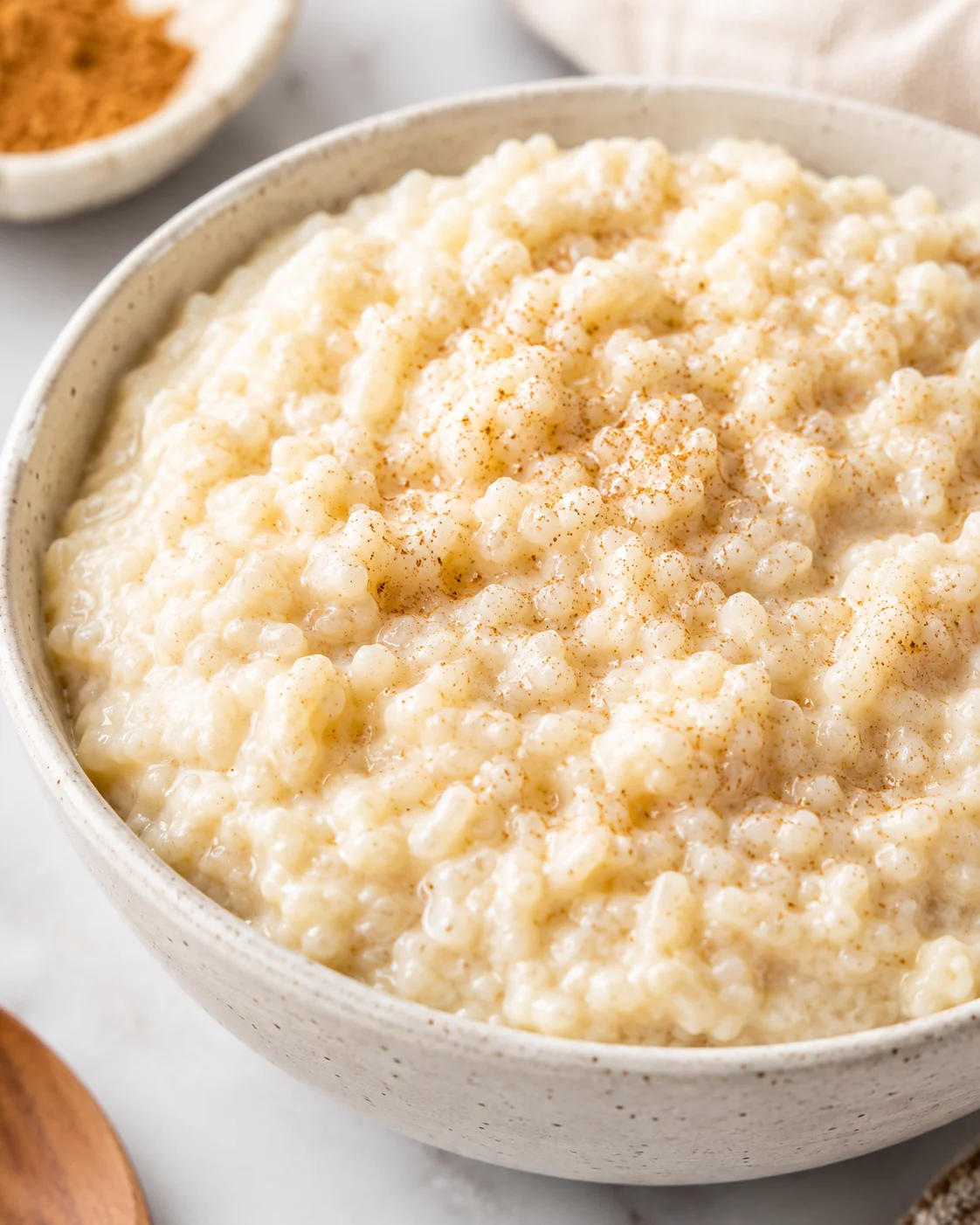 Creamy Slow Cooker Rice Pudding Delicious creamy rice pudding served in a bowl, topped with cinnamon.