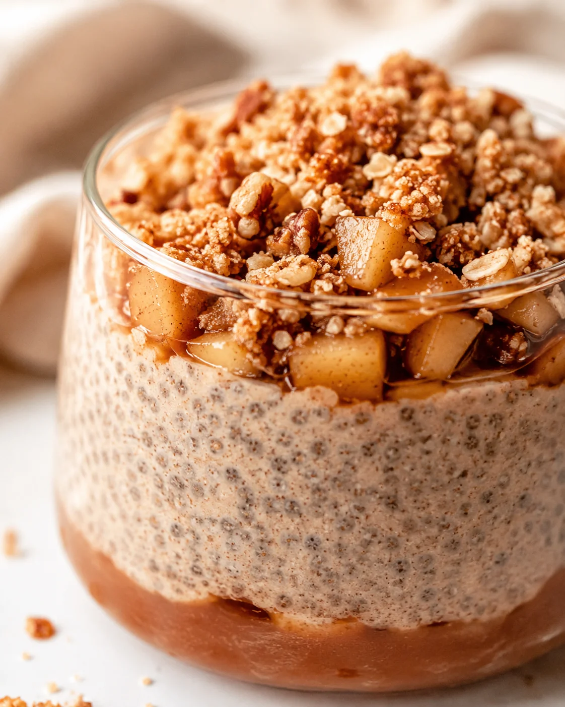 Close-up of creamy apple crumble chia pudding topped with stewed apples and crumble