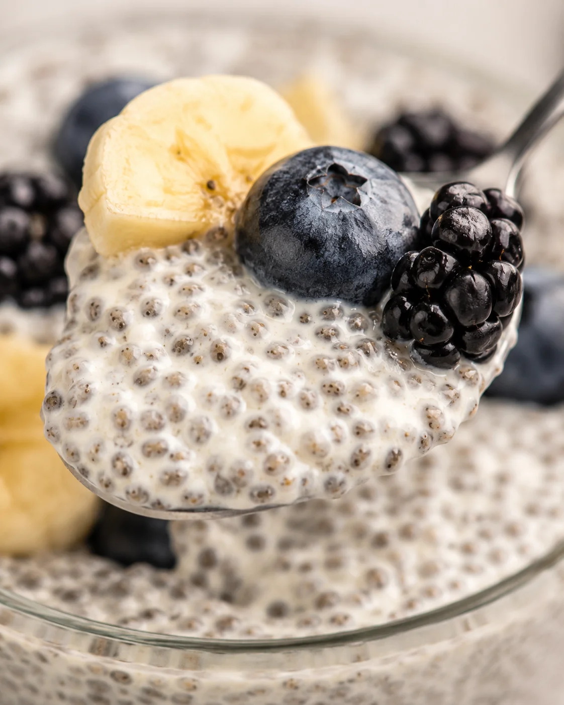 Creamy Vanilla Chia Pudding Close-up of vanilla chia pudding topped with blueberries, banana slices, and blackberries
