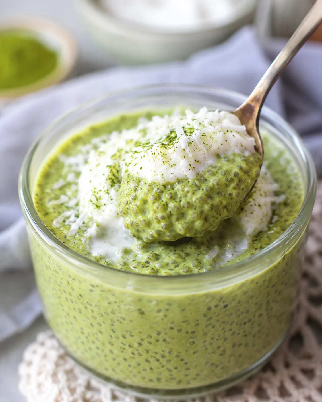 Creamy green matcha chia pudding with coconut topping in a glass