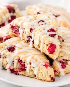 Stack of glazed cranberry scones on a white plate, close-up