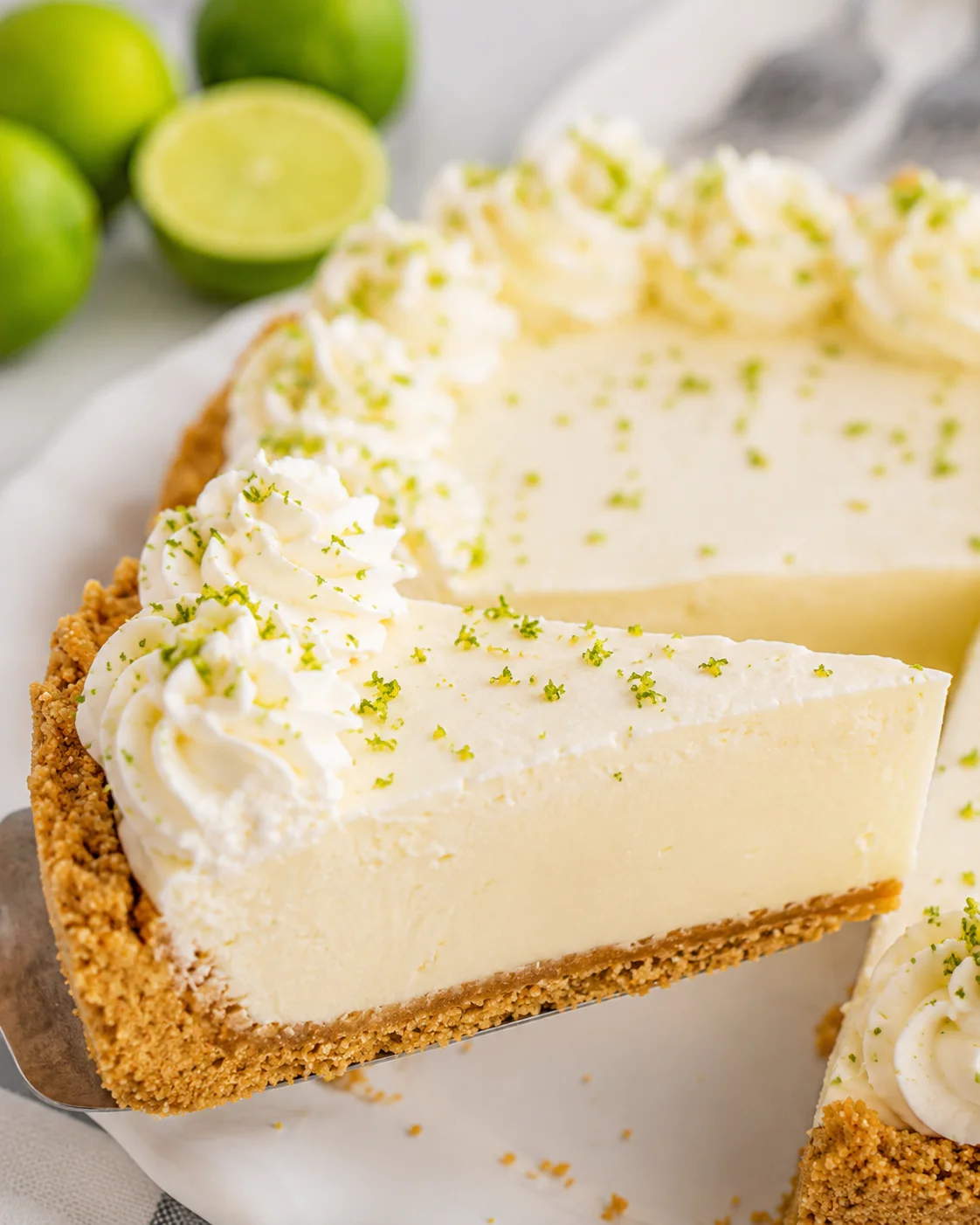 Single slice of no-bake key lime pie on a pie server showing graham cracker crust and creamy filling
