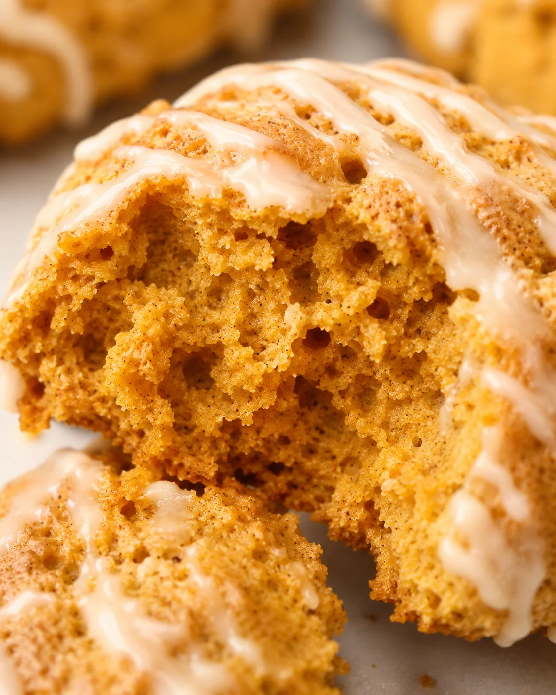 Macro view of the interior crumb of a maple pumpkin scone with glaze.