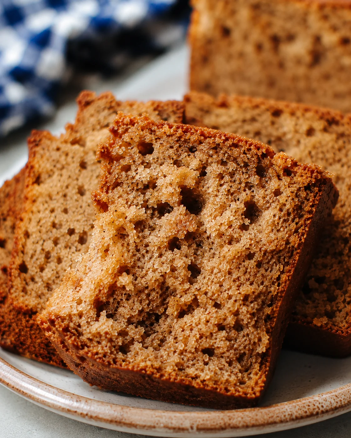 Freshly sliced moist cinnamon applesauce bread with warm spices on a plate.
