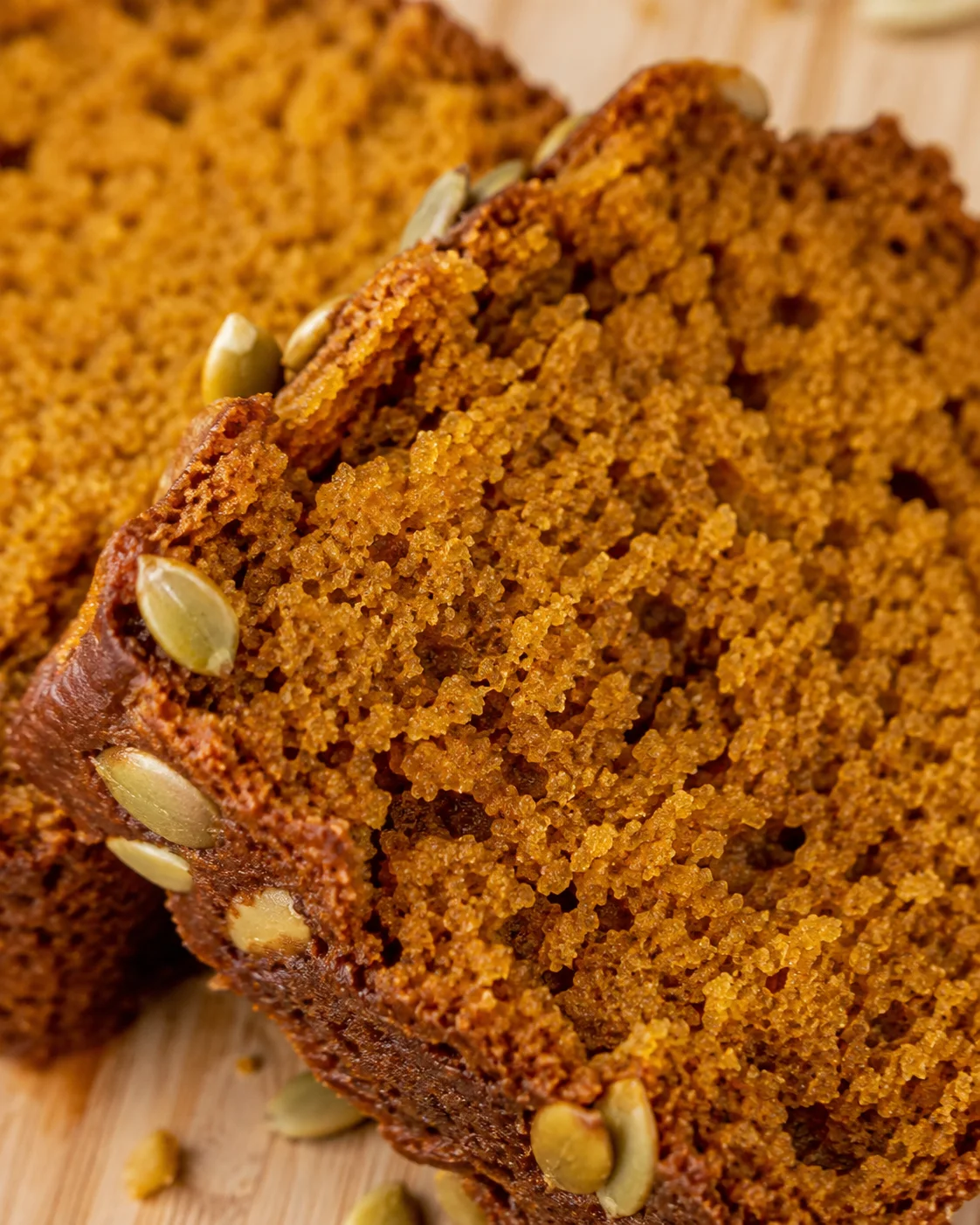Close-up of the moist crumb texture of Starbucks pumpkin bread with a few pumpkin seeds
