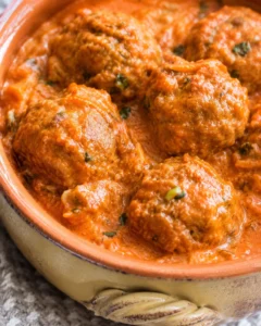 Pumpkin turkey meatballs simmering in creamy harvest tomato sauce in a rustic casserole