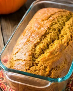 loaf of sweetened condensed milk pumpkin bread in a glass loaf pan, close-up